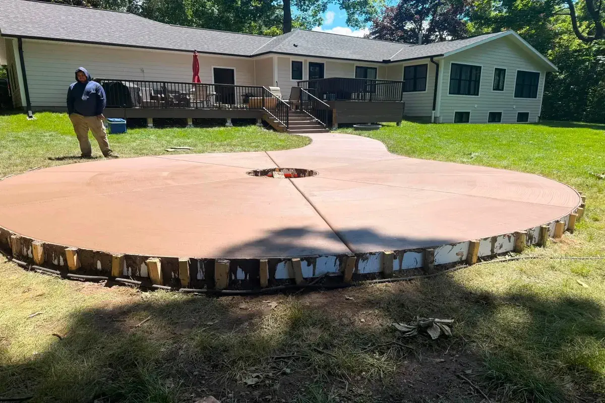 Curved concrete patio and walkway leading up to a back deck