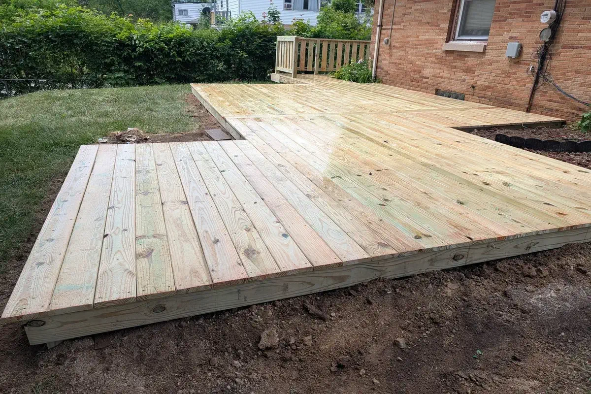Ground level wood deck built out over a cleared backyard