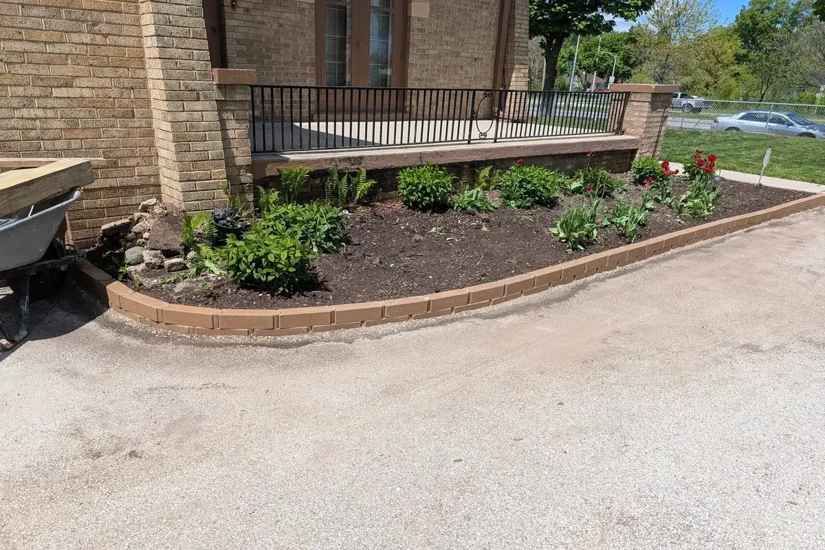 Low block wall edging a planted garden bed at a building corner
